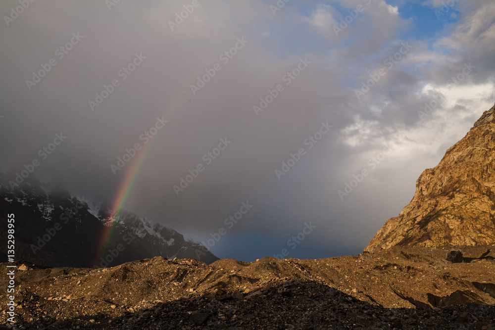 Beautiful evening. Rainbow in the mountains and cloudy sky