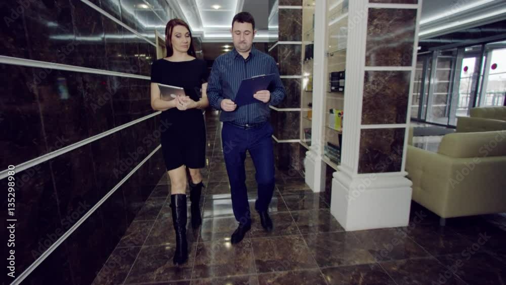 businessman and businesswoman going in doorway businessman and businesswoman going in doorway