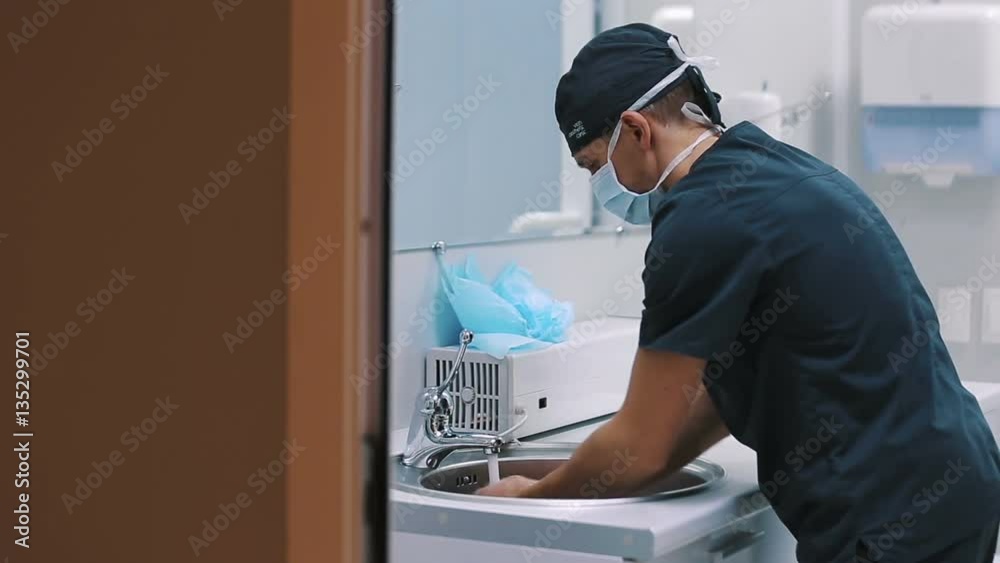 Male surgeon washes his hands before the operation Male surgeon washes his hands before the operation