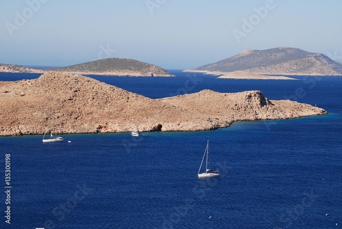 Sailing boats head into Emborio harbour on the Greek island of Halki. photo