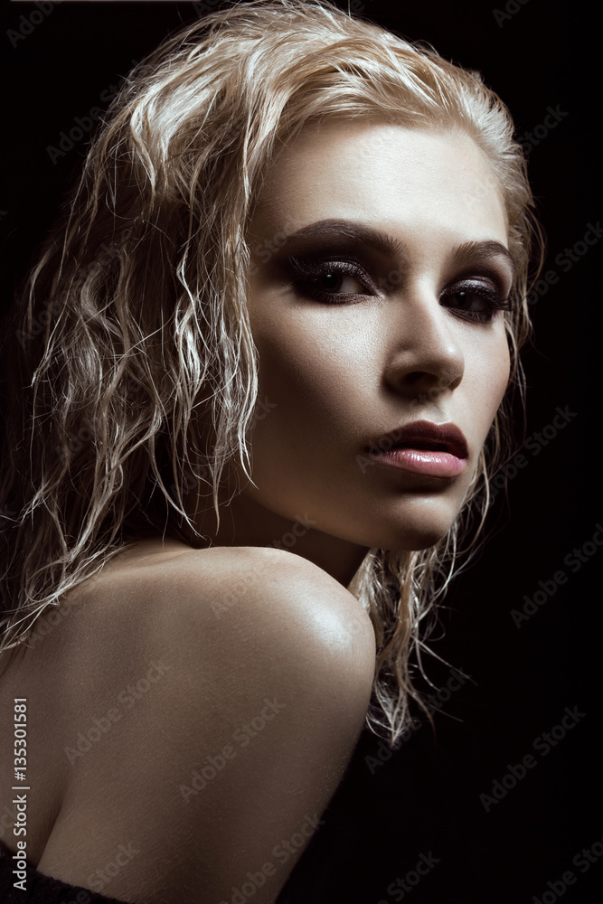 Beautiful girl with a bright make-up and wet hair and skin. Beauty face. Picture taken in the studio on a black background. Beautiful girl with a bright make-up and wet hair and skin. Beauty face. Picture taken in the studio on a black background.