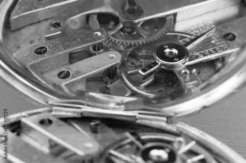 macro view of an antique pocket watch mechanism reflected in its dust cover 