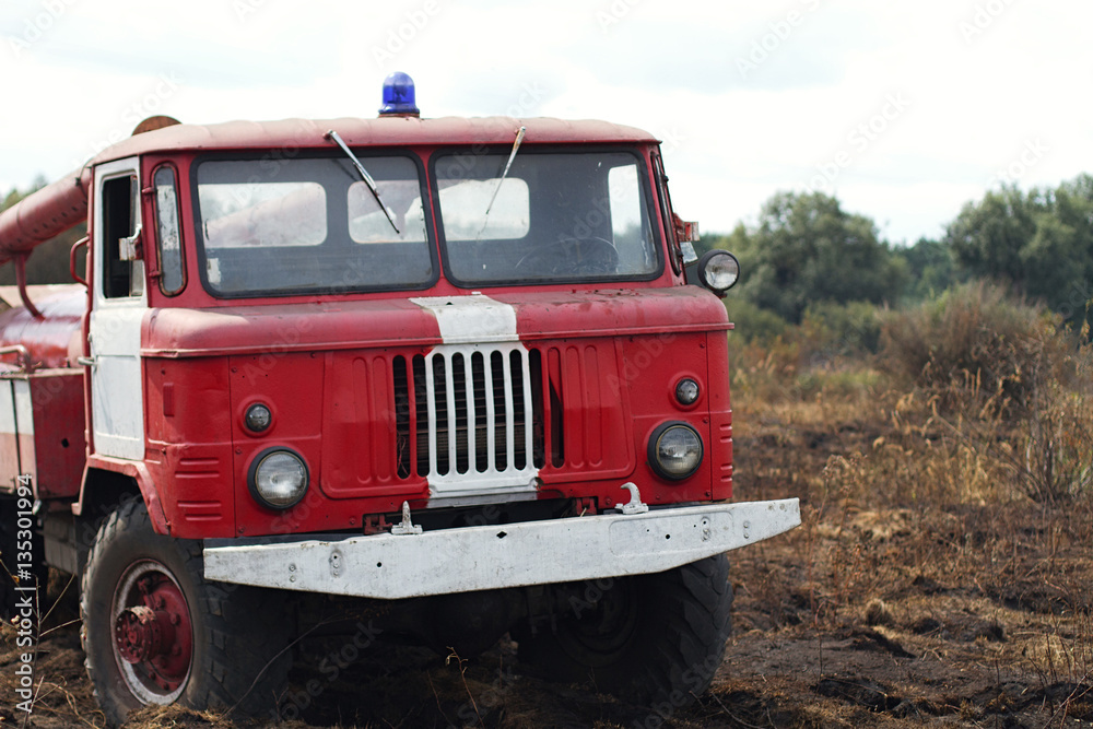 fire truck puts out in a field a forest fire