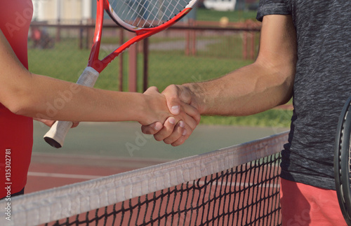 Young players shaking hands on tennis court. Only hands can be seen. © Nastassia Yakushevic