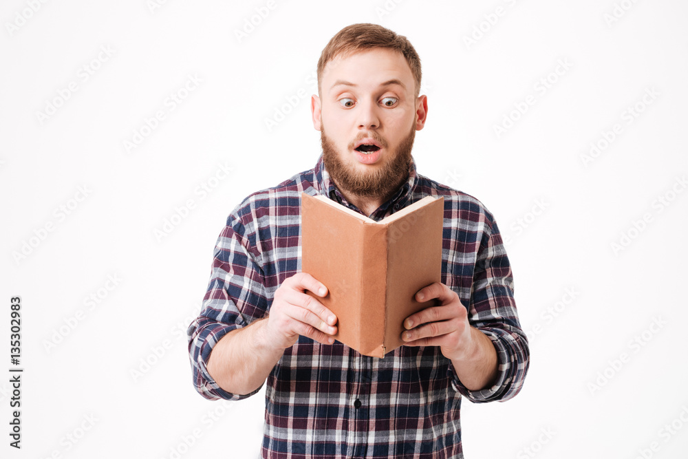 Surprised Bearded man in shirt reading book Surprised Bearded man in shirt reading book