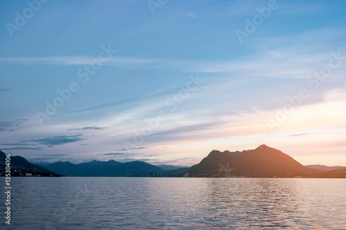 Water  hills and sky. Mountains and town at distance. Lake Maggiore in summer.