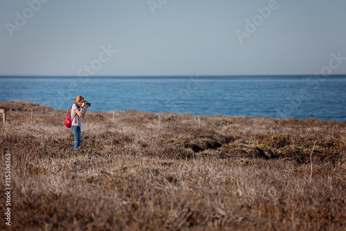 Young lady with rucksack taking a picture