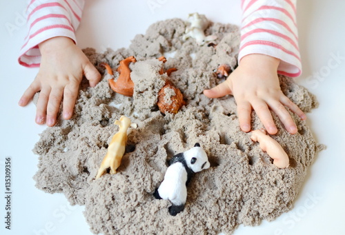Little baby girl age of 1,9 years play with kinetic sand