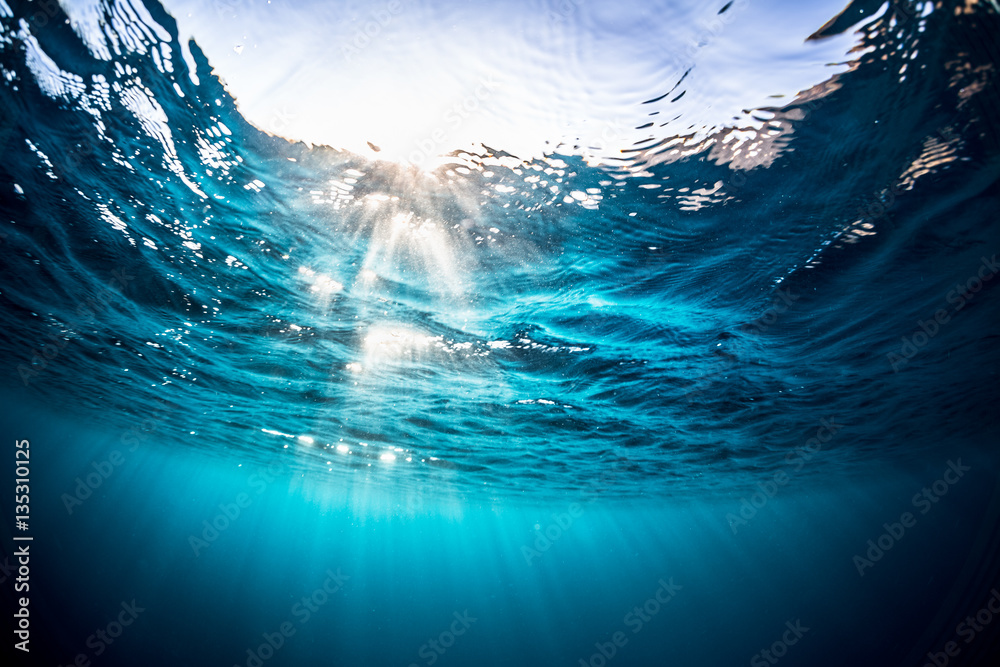 Underwater shot of the sea surface with sunny beams and waves - obrazy, fototapety, plakaty 