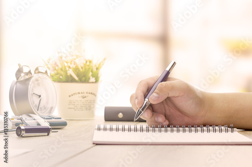 Businessman making notes at the office meeting with computer laptop and glasses.