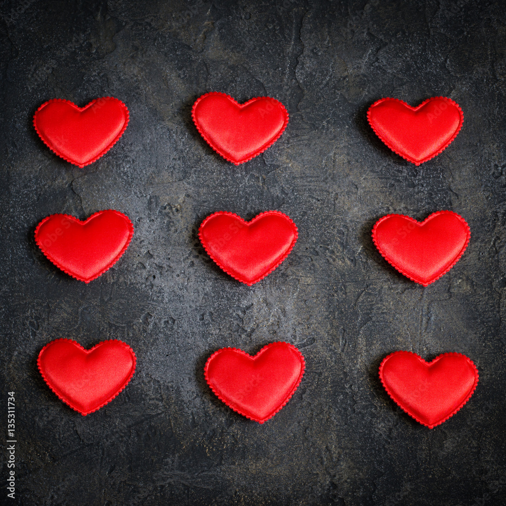 Satin red hearts on a dark background. Valentine's Day card.