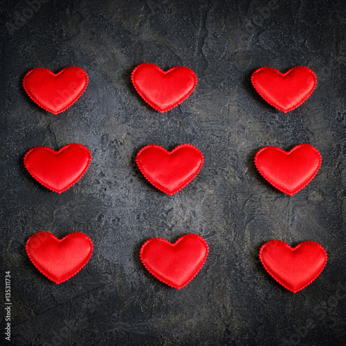 Satin red hearts on a dark background. Valentine s Day card.