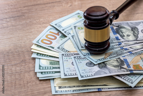 wooden gavel with usa dollar on desk. close up.