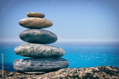 Zen Balancing Pebbles on Beach on sea background