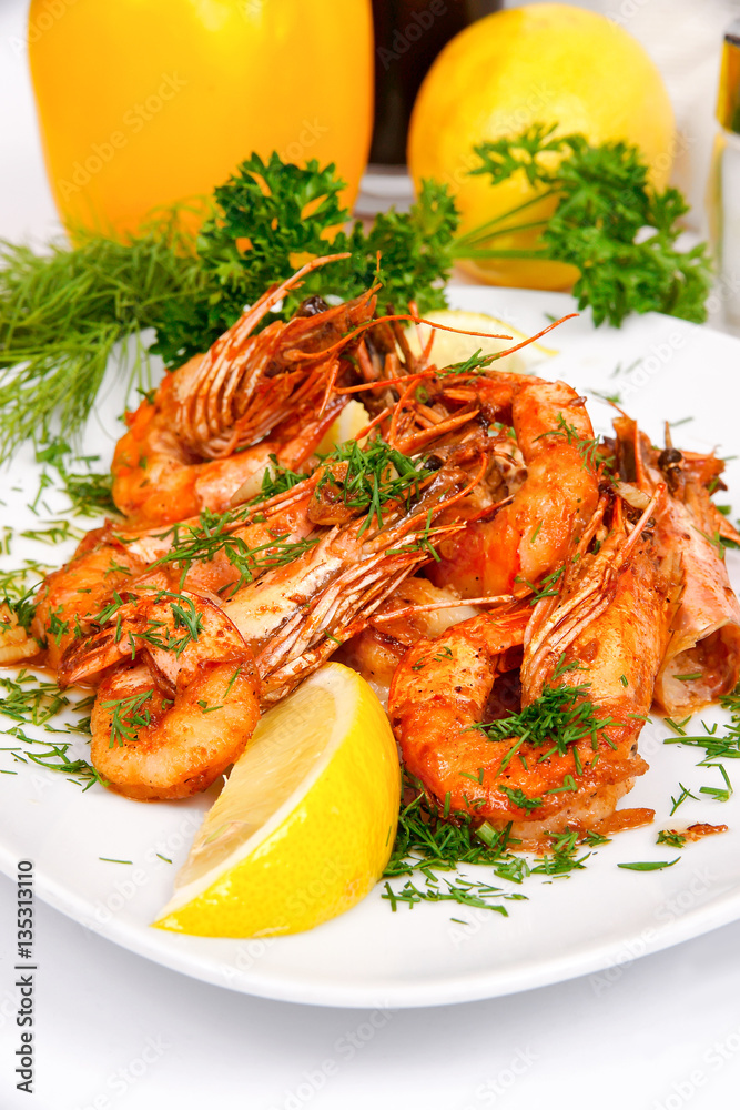 Fragrant shrimp in Chinese style with greens on a white plate Fragrant shrimp in Chinese style with greens on a white plate