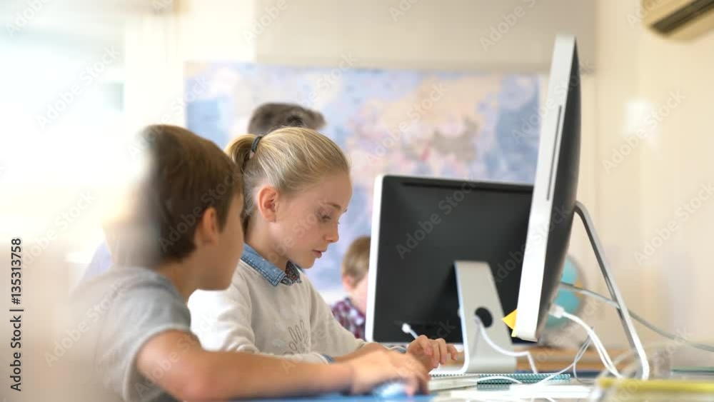 Teacher with school kids in computer laboratory Teacher with school kids in computer laboratory
