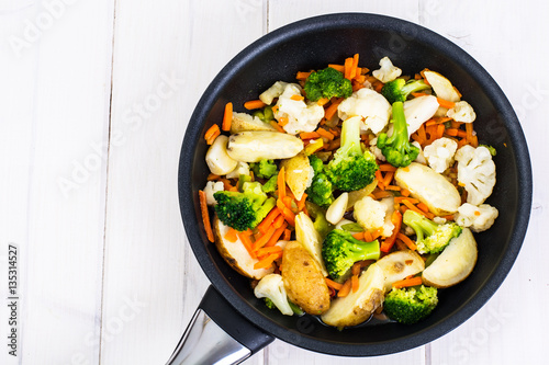 Broccoli, cauliflower, potatoes, carrots cooked in a frying pan 