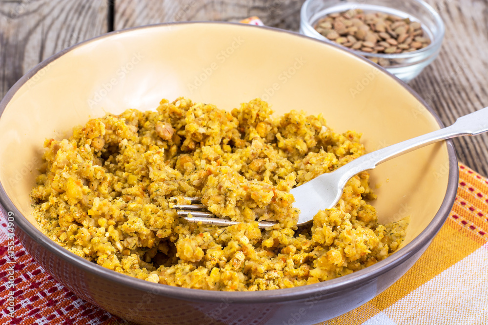 Side dish of lentils with vegetables, butter in bowl on wooden b Side dish of lentils with vegetables, butter in bowl on wooden b