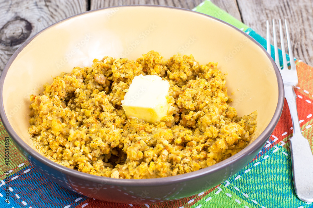 Side dish of lentils with vegetables, butter in bowl on wooden b Side dish of lentils with vegetables, butter in bowl on wooden b
