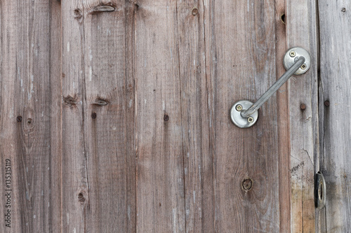Closed and unlocked wooden old door with handle, lock eyelets and nail heades © Woody Alec