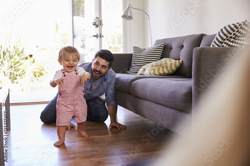 Photos Parents Watching Baby Daughter Take First Steps At Home