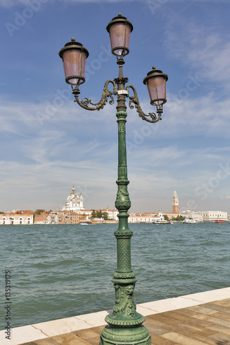 Old street light and Venice cityscape, view fron lagoon. Italy.