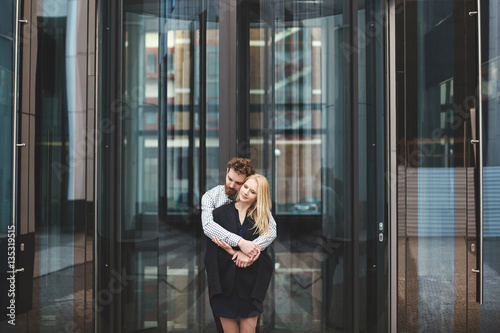 Love Story. The guy hugs the girl. Glass building. © Artem Zakharov