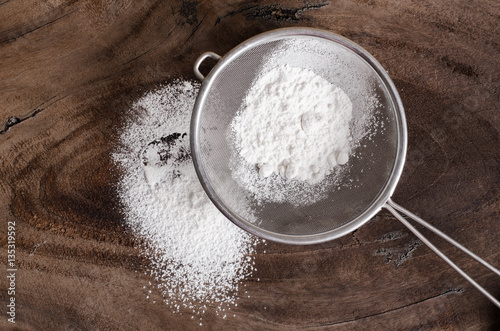 Wheat flour in a sieve on wooden background,food ingredient,prepare for cooking or baking photo