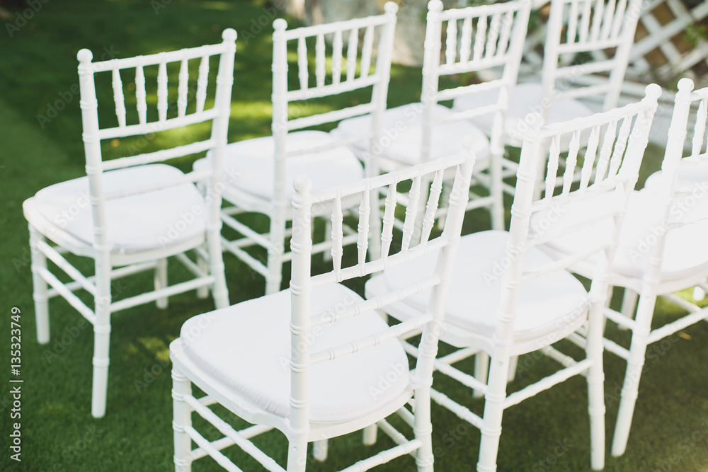 Fototapeta premium Beautiful white wedding chairs at the ceremony in the Park.