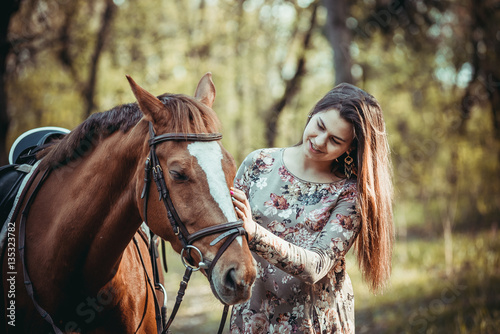 Young girl with a horse in the forest. © sergo321