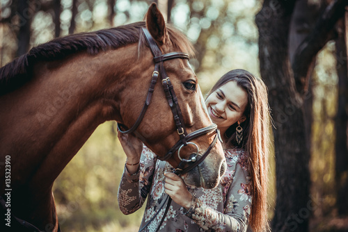 Young girl with a horse in the forest.