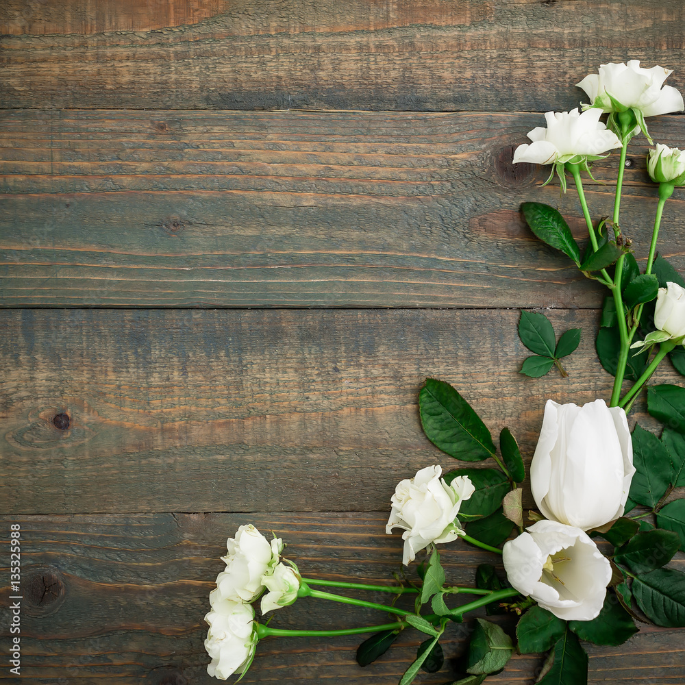 Frame made of flowers, green leaves, branches on wood background. Flat lay, top view. Valentine's background Frame made of flowers, green leaves, branches on wood background. Flat lay, top view. Valentine's background