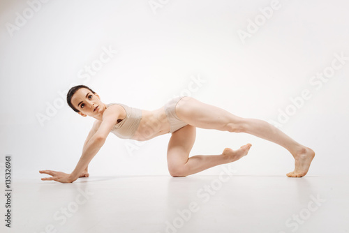 Energetic athlete performing in the white colored room