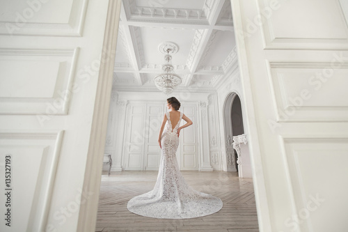 Fototapete Beautiful bride posing in wedding dress in a white photo Studio.