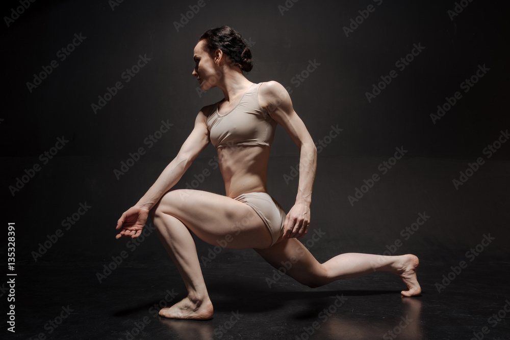 Confident young dancer acting in the white studio