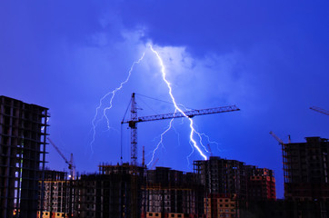 Keuken achterwand Onweer Bliksem boven bouwkraan in nachtstad  © aapsky