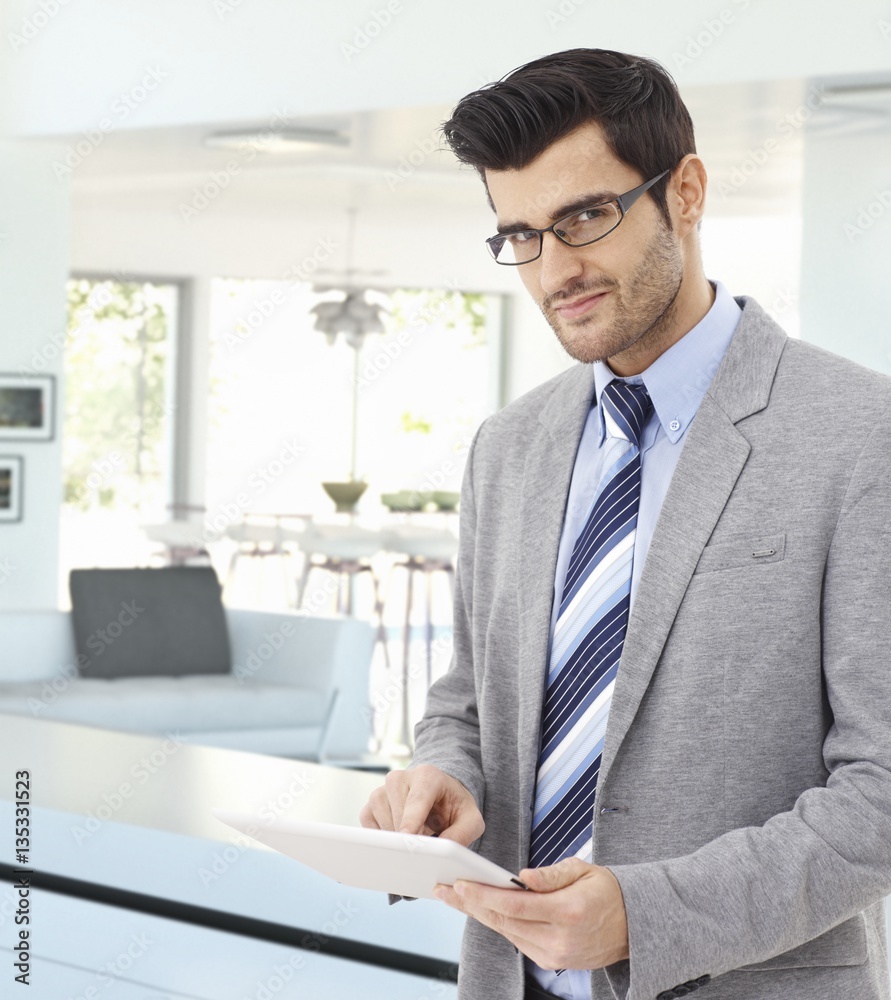 Handsome businessman at home with tablet in hand Handsome businessman at home with tablet in hand
