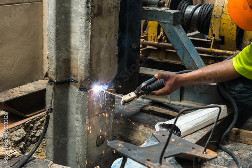 Welder worker is welding a big stake body