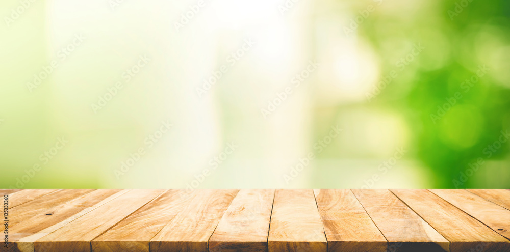 Empty wood table top on blur abstract green garden from window