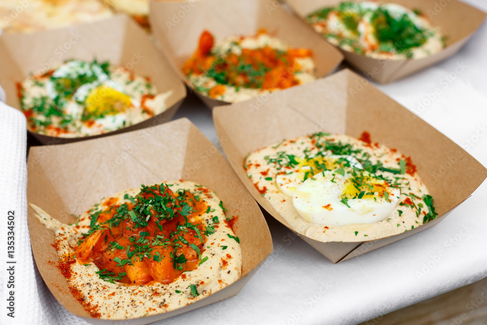 Street vendor's hummus, closeup of snacks in craft package Street vendor's hummus, closeup of snacks in craft package