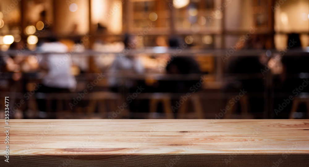 Wood table top on blurred of cafe ( restaurant ) with people background.