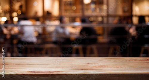 Wood table top on blurred of cafe ( restaurant ) with people background.
