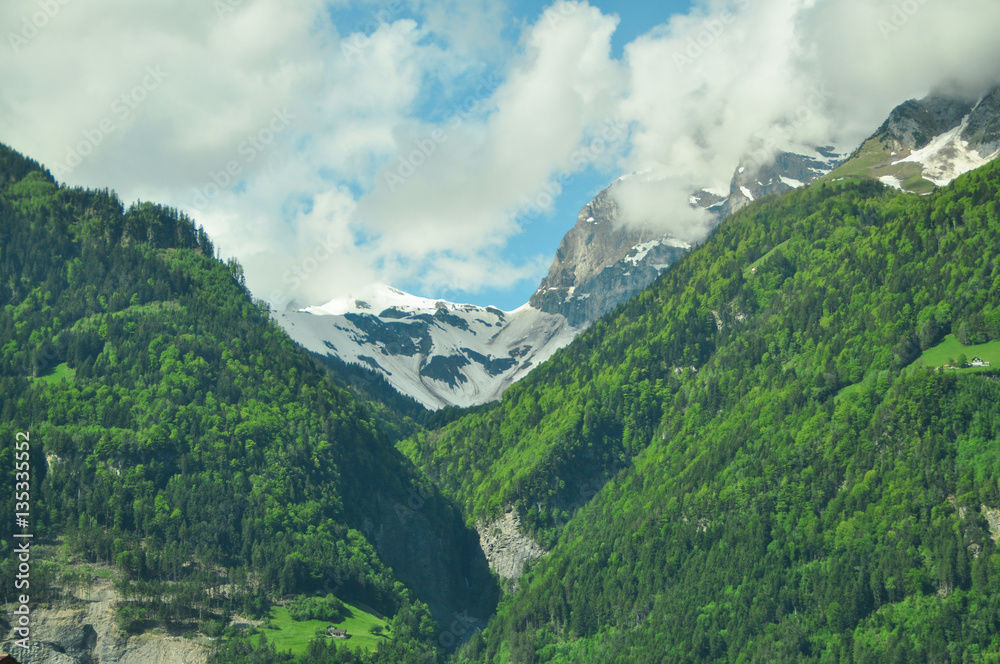 Fototapeta premium Green mountains and clouds in Switzerland