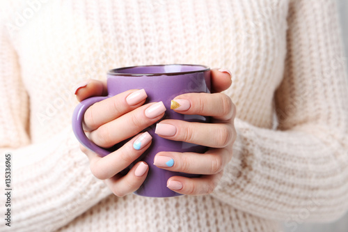 Woman hands with manicure holding cup of coffee