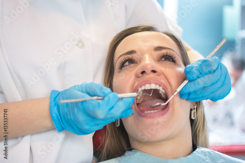 Dentist examining a patient s teeth in the dental office.