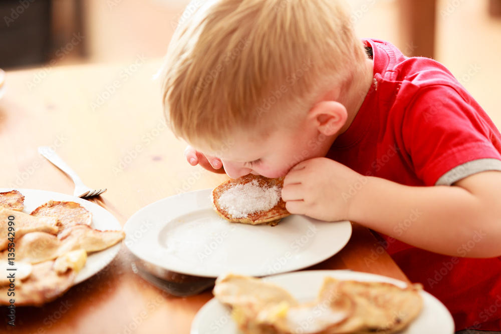 Little boy eating pancakes for breaktfast Little boy eating pancakes for breaktfast