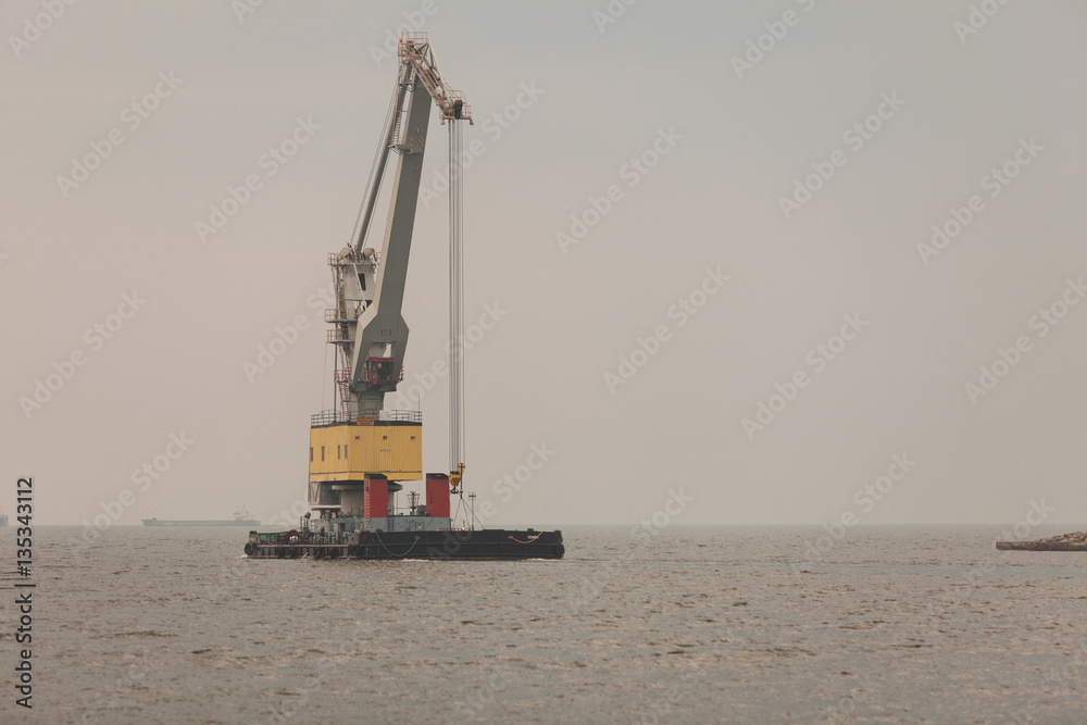 Indurstrial bay with metal crane on water