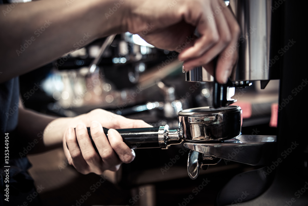 Barista making coffee with machine,stamp tool in cafe in vintage
