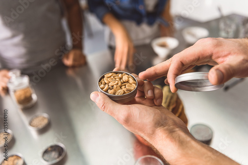 Man holding jar with coffee beans
