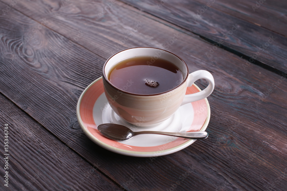 Obraz premium cup of black tea on a wooden table